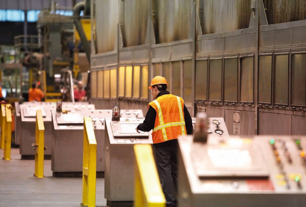 stock photo - workers in hard hats Worker in hardhat and safety vest operating a control panel