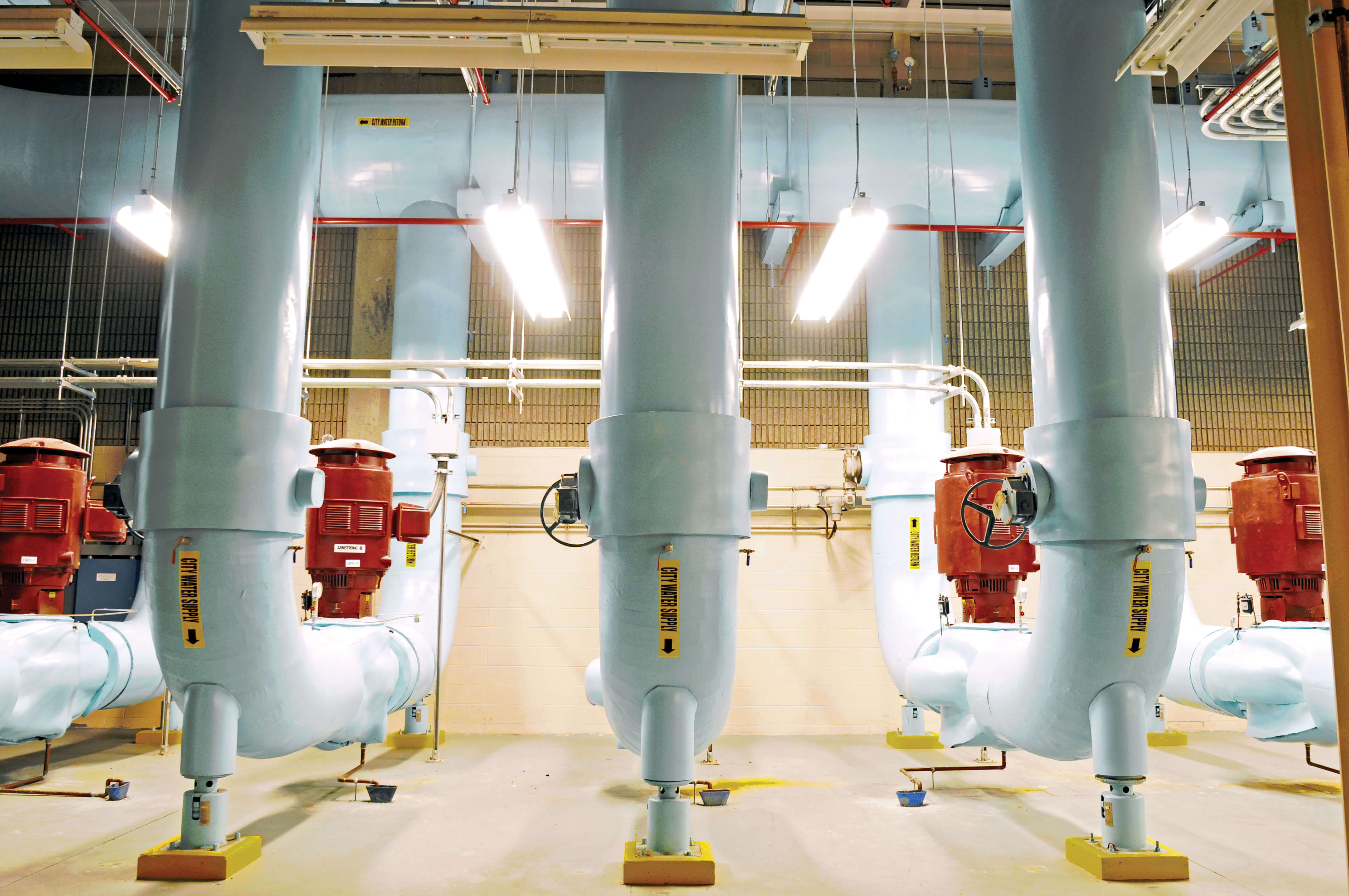 Array of massive white cooling pipes and red pumps