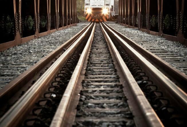 Closeup of railroad tracks with oncoming train in distance