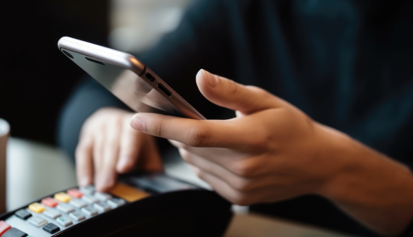 person using phone and credit card machine