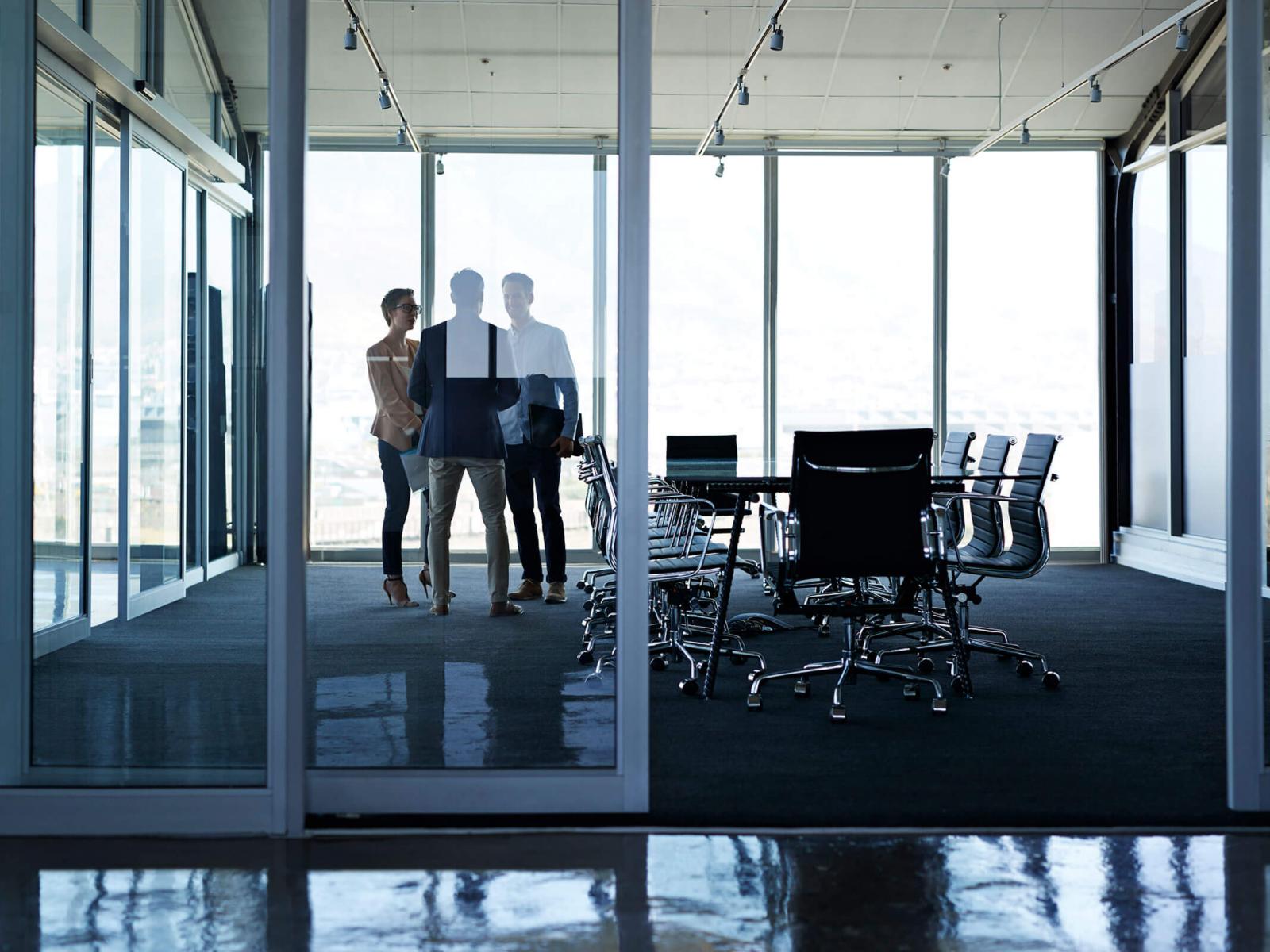 Three office workers talking in conference room