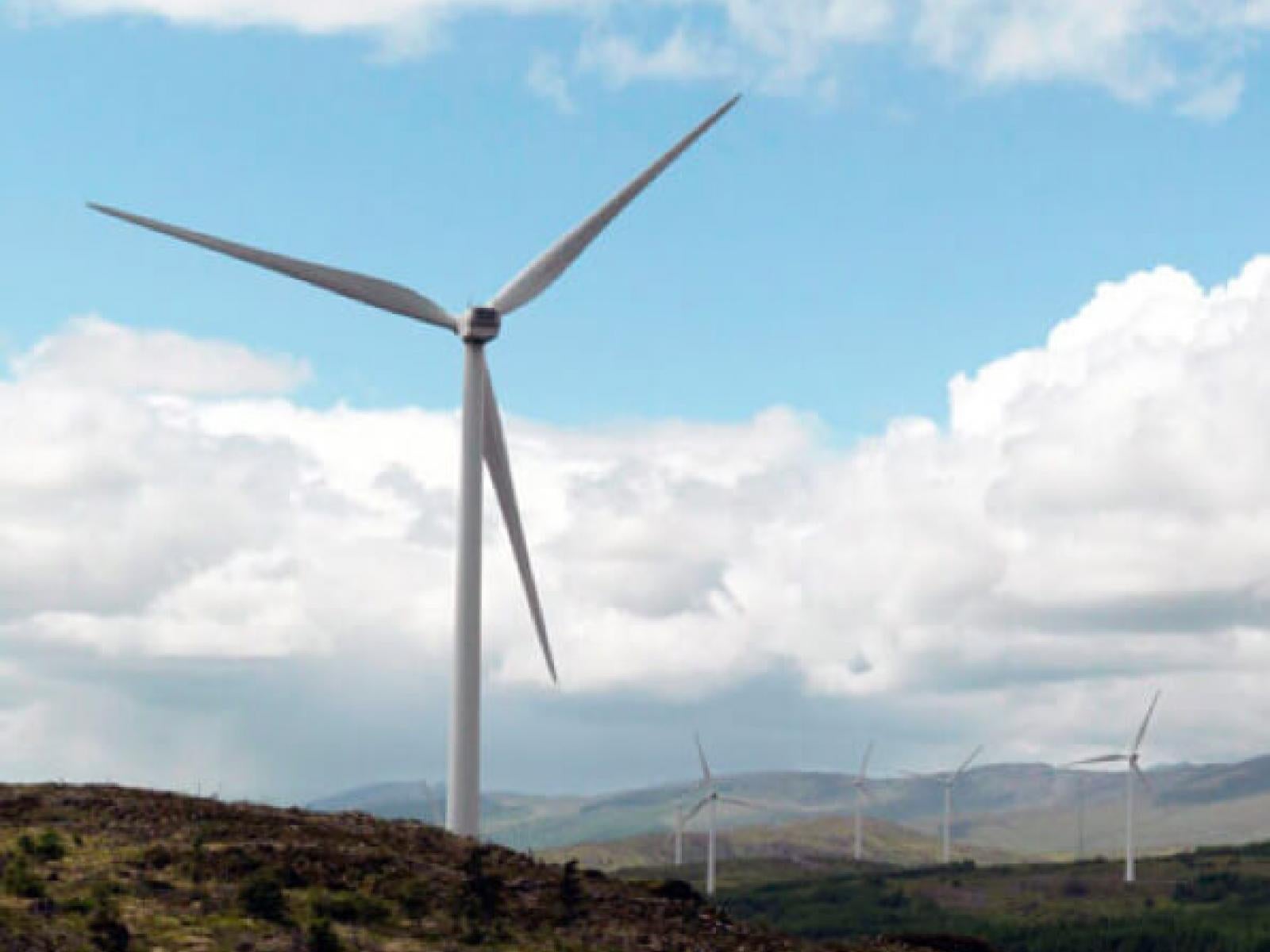 single windmill in Ireland Windmill on hillside; white fluffy clouds in background