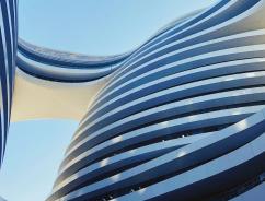 Curved building with a bridge daytime 