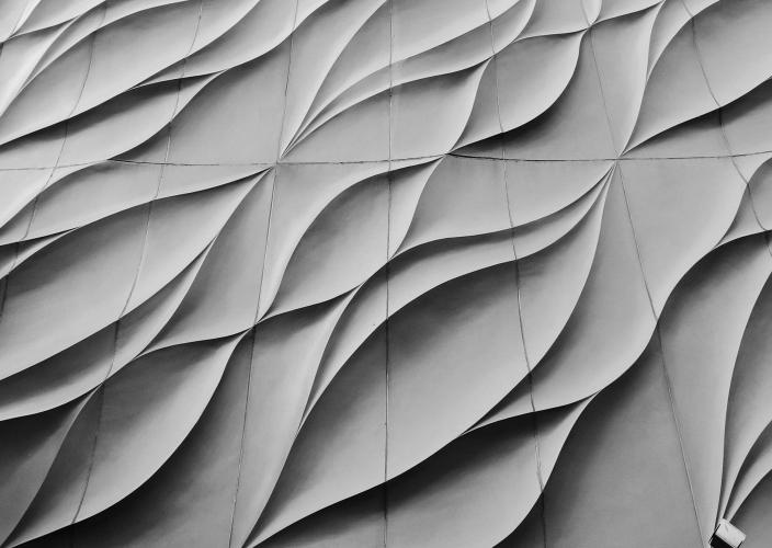 Architectural facade with wavy concrete panels in flowing design