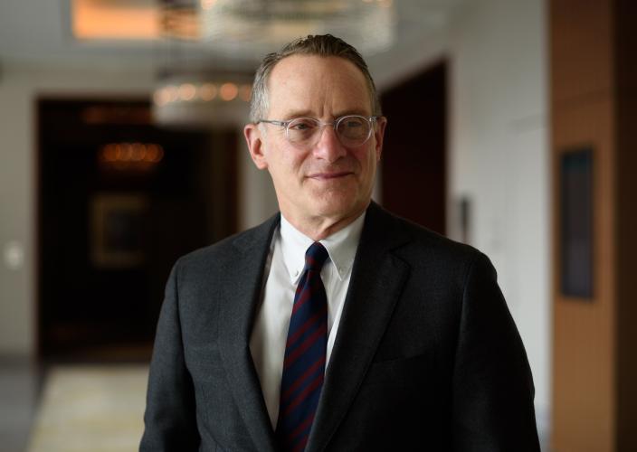 howard marks, man standing in a hallway wearing a suit