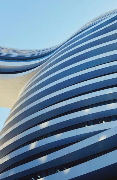 Curved building with a bridge daytime 