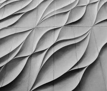 Architectural facade with wavy concrete panels in flowing design