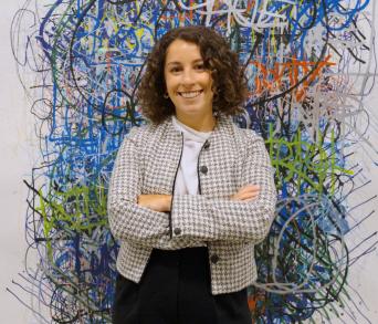 Taylor Denara infront of artwork in New York office