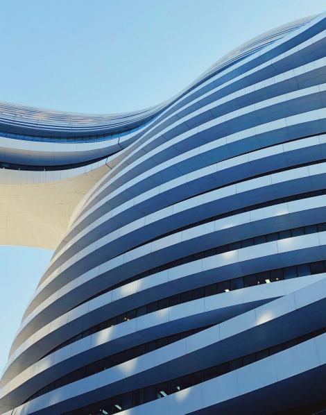 Curved building with a bridge daytime 