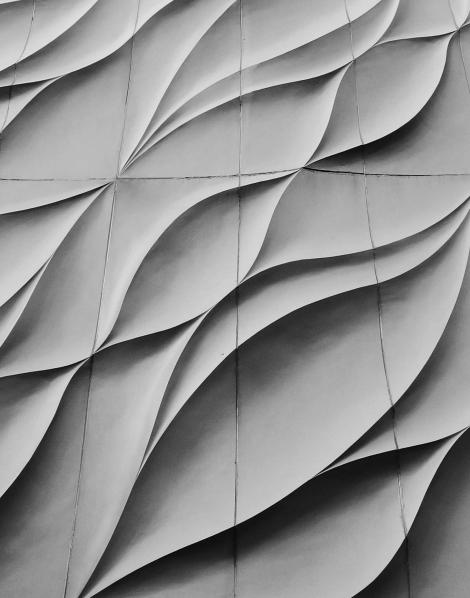 Architectural facade with wavy concrete panels in flowing design