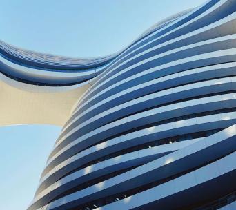 Curved building with a bridge daytime 