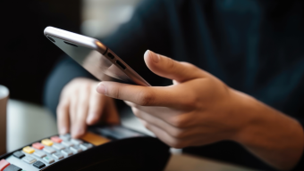 person using phone and credit card machine