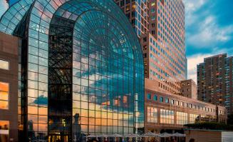 Sunset reflected in vaulted three-story windows of the Winter Garden