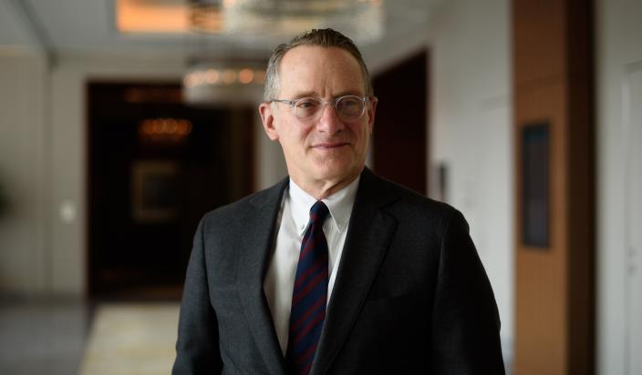 howard marks, man standing in a hallway wearing a suit